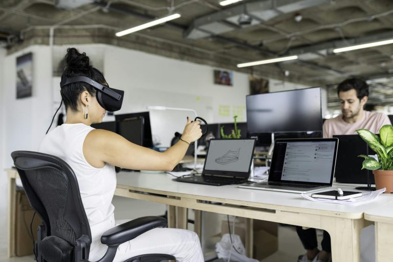 Woman using virtual reality headset in a modern office for design and innovation.